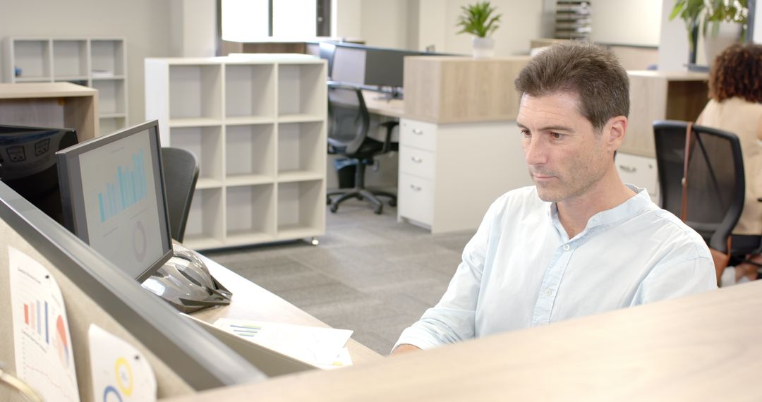 Businessman Analyzing Data Charts in Modern Office Workspace
