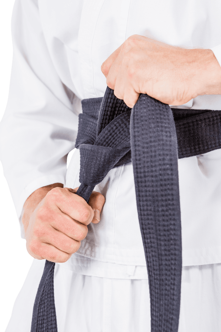 Close-Up of Karateka in Karate Gi Adjusting Black Belt on Transparent Background