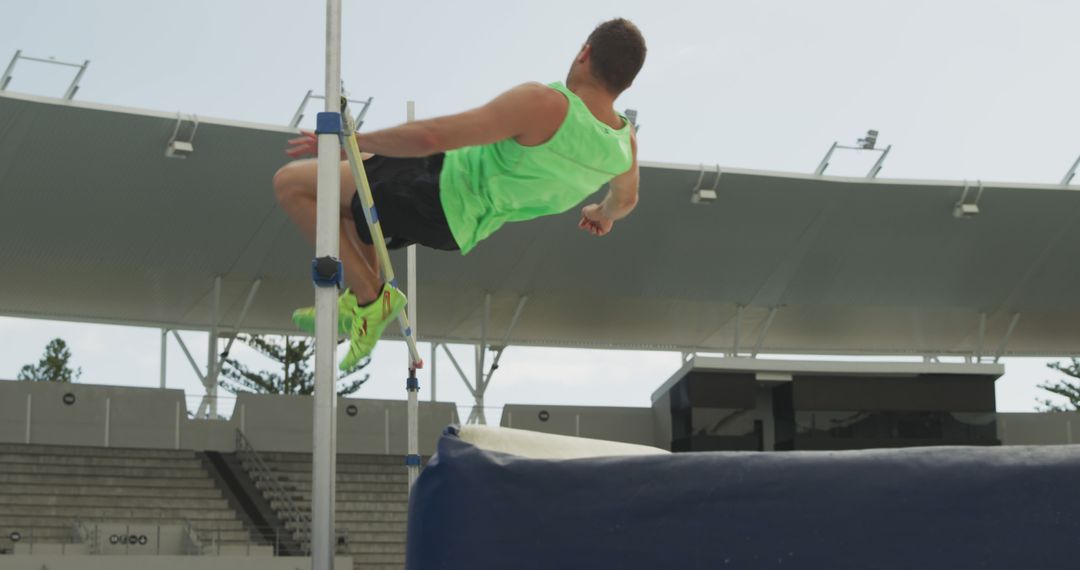 Male Athlete in Mid-Air During High Jump Competition - Free Images, Stock Photos and Pictures on Pikwizard.com