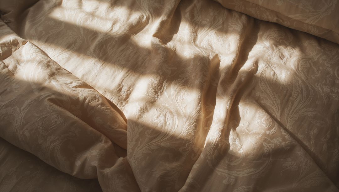 Beige Damask Duvet Unfolding in Warm Window Light with Soft Pillow and Shadows