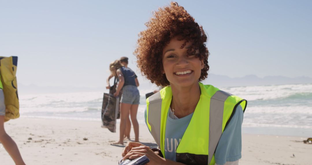 Smiling Volunteer Cleaning Beach with Group - Free Images, Stock Photos and Pictures on Pikwizard.com