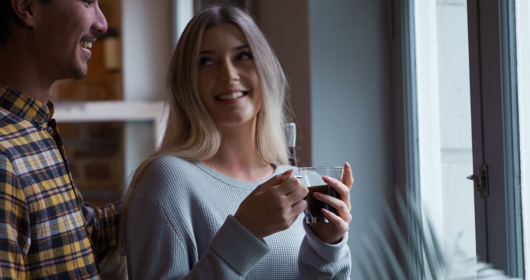 Happy Couple Sharing Coffee Relaxing by Window at Home