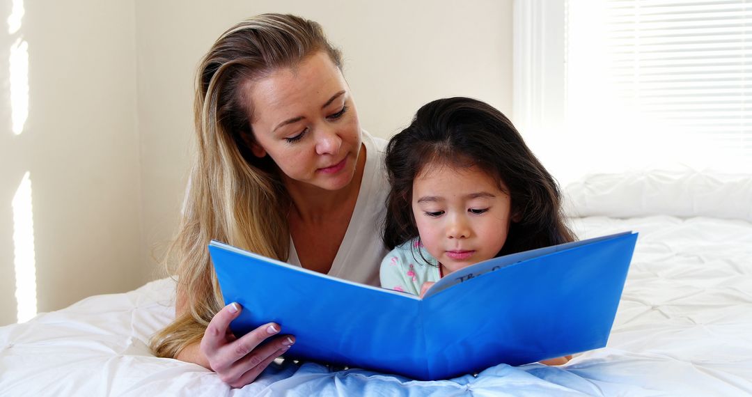 Mother Reading Book to Daughter on Bed in Bright Bedroom - Free Images, Stock Photos and Pictures on Pikwizard.com