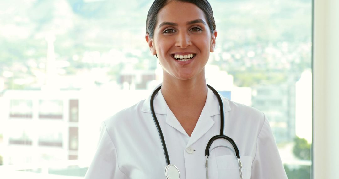 Smiling Female Doctor in White Coat with Stethoscope in Bright Office - Free Images, Stock Photos and Pictures on Pikwizard.com