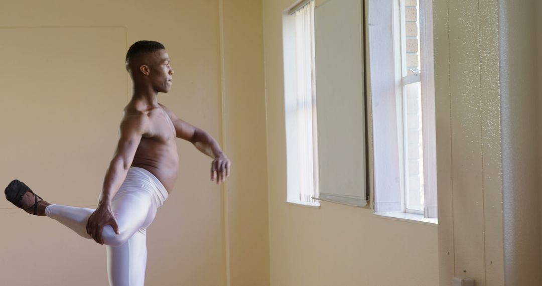 Male Ballet Dancer Stretching in Bright Room by Window - Free Images, Stock Photos and Pictures on Pikwizard.com