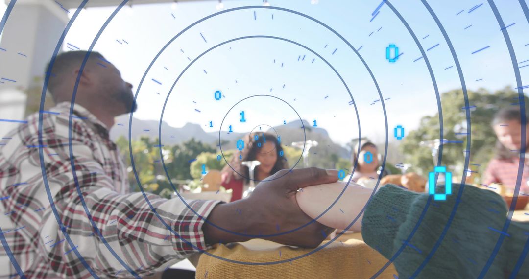 Holding hands across sunlit terrace table with augmented reality data overlay
