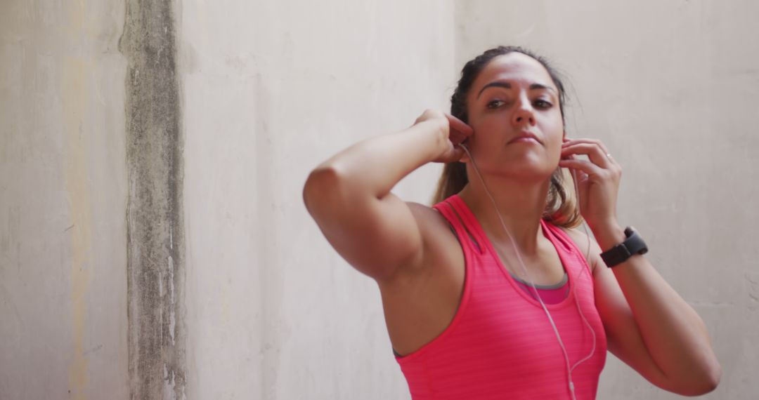 Young Woman Preparing for Outdoor Workout with Earphones - Free Images, Stock Photos and Pictures on Pikwizard.com