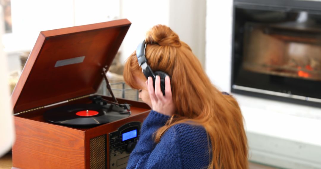 Red-haired woman listens to record player in cozy living room setting - Free Images, Stock Photos and Pictures on Pikwizard.com