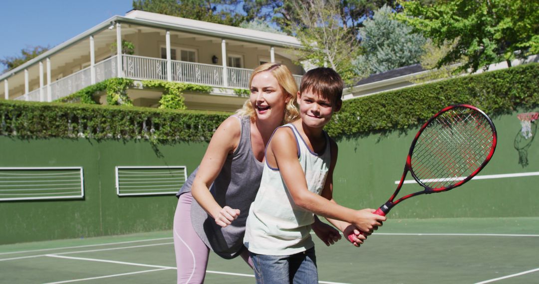 Mother and Son Learning Tennis Outdoors on Sunny Day - Free Images, Stock Photos and Pictures on Pikwizard.com