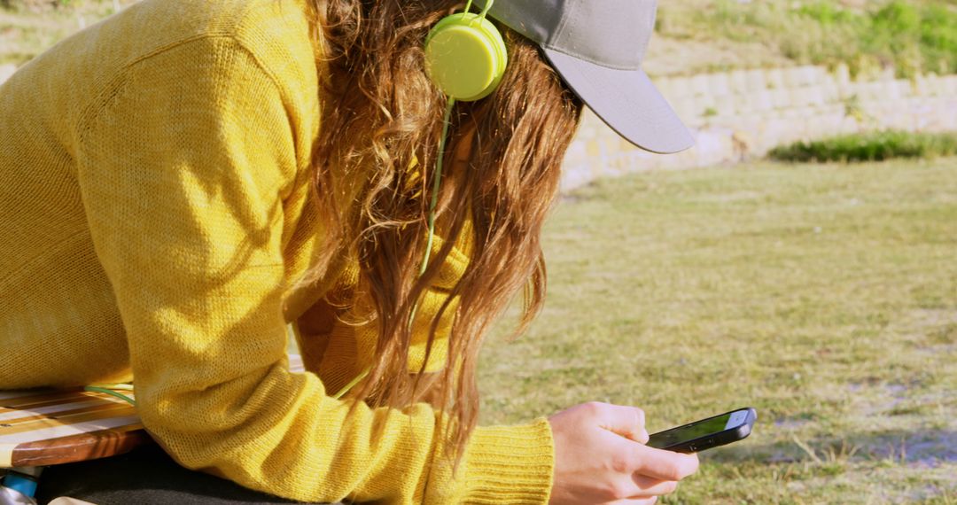 Young Woman Listening to Music on Smartphone in Park - Free Images, Stock Photos and Pictures on Pikwizard.com