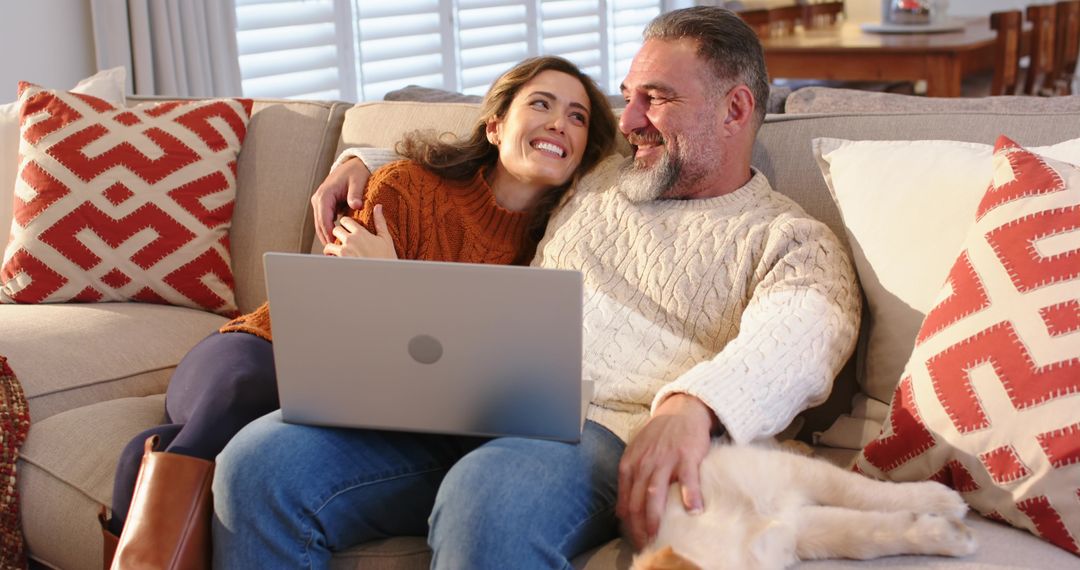Couple Cuddling on Sofa Using Laptop and Petting Ginger-White Cat, Cozy Home Moment Scene