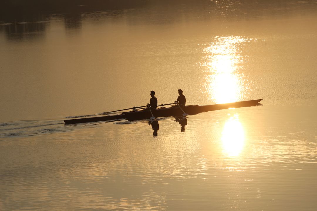 Two People Rowing Canoe at Sunset on Calm Water - Free Images, Stock Photos and Pictures on Pikwizard.com