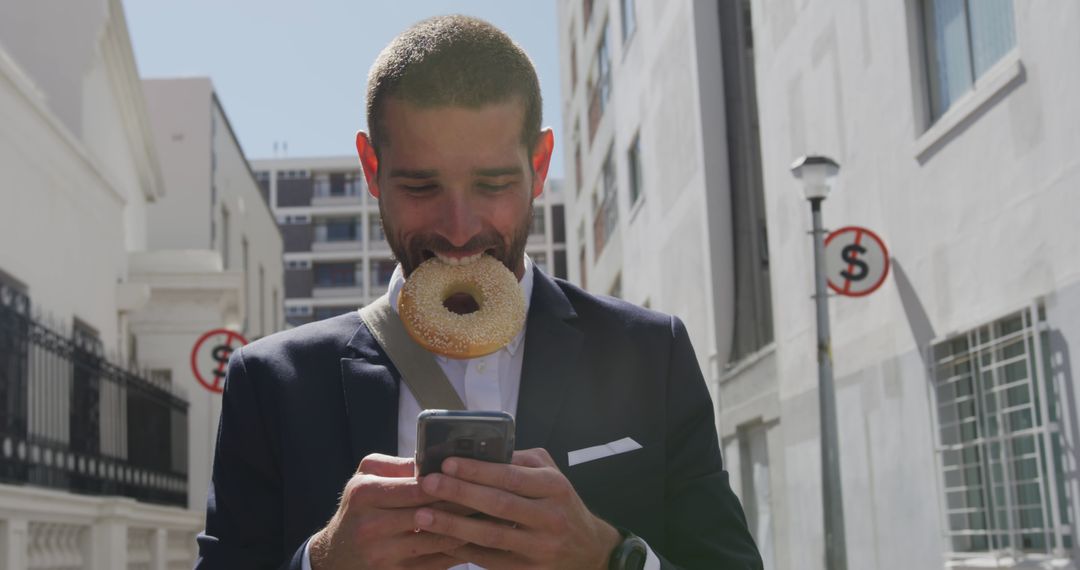 Businessman Eating Bagel Using Smartphone Urban Street - Free Images, Stock Photos and Pictures on Pikwizard.com