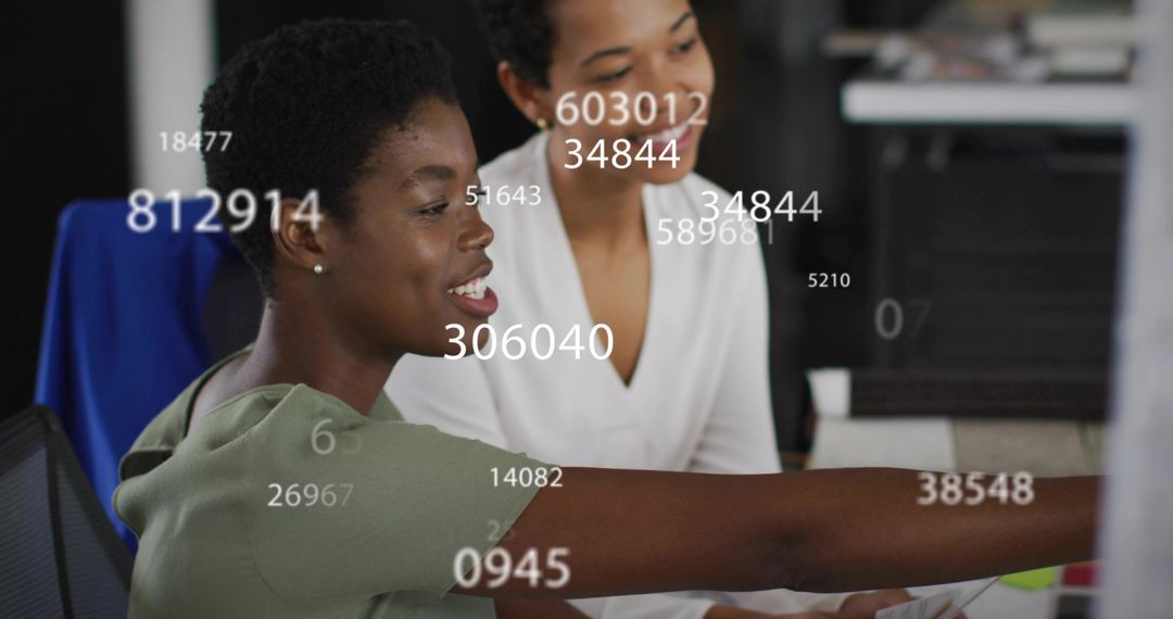 Two Women Collaborating on Data Analysis at Modern Office