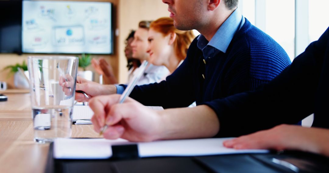 Focused Professionals in Corporate Meeting with Note-taking