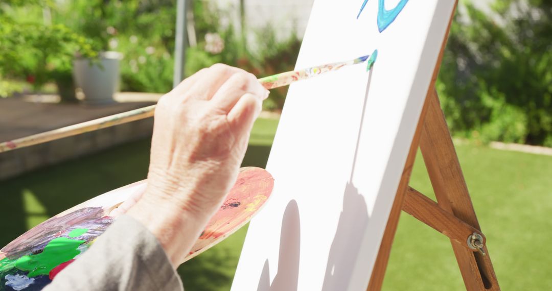 Elderly Person Painting on Canvas Outside on Sunny Day - Free Images, Stock Photos and Pictures on Pikwizard.com