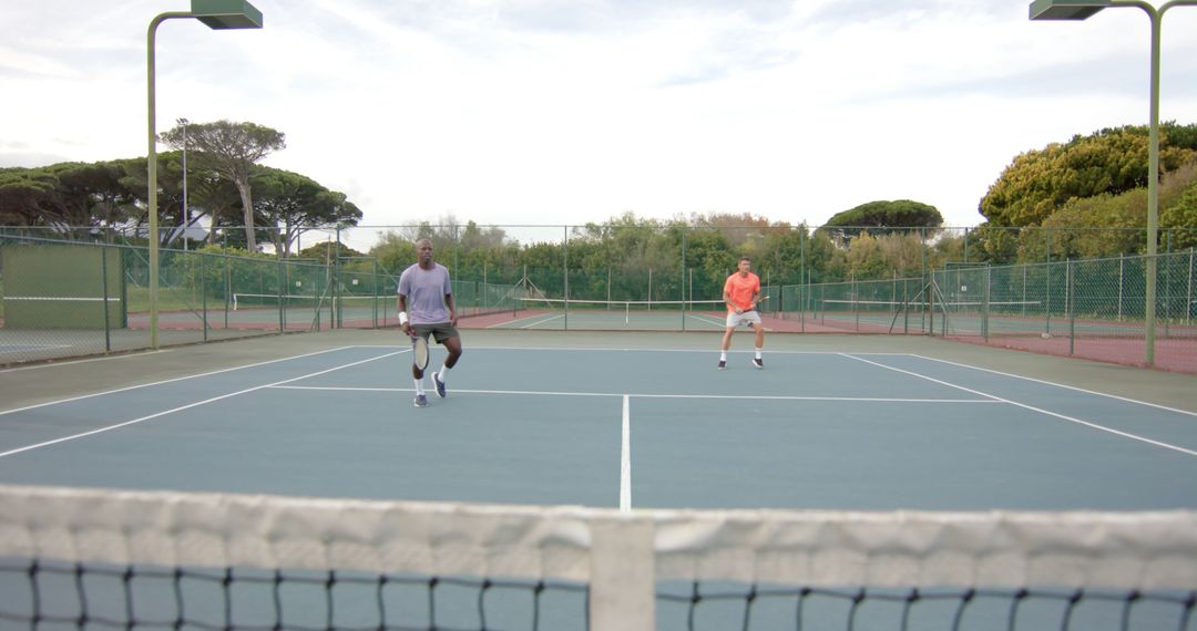 Two Men Playing Tennis on an Outdoor Court - Free Images, Stock Photos and Pictures on Pikwizard.com