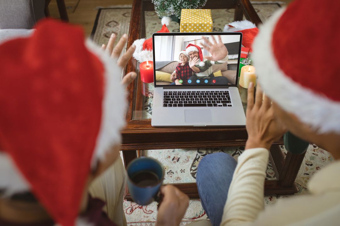 Diverse Couple with Santa Hats Video Calling Friends on Laptop During Christmas Celebration - Free Images, Stock Photos and Pictures on Pikwizard.com