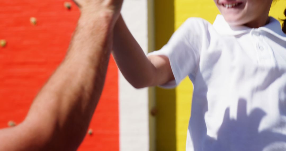 Close-up of Child High-Fiving Person in Brightly Colored Background - Free Images, Stock Photos and Pictures on Pikwizard.com