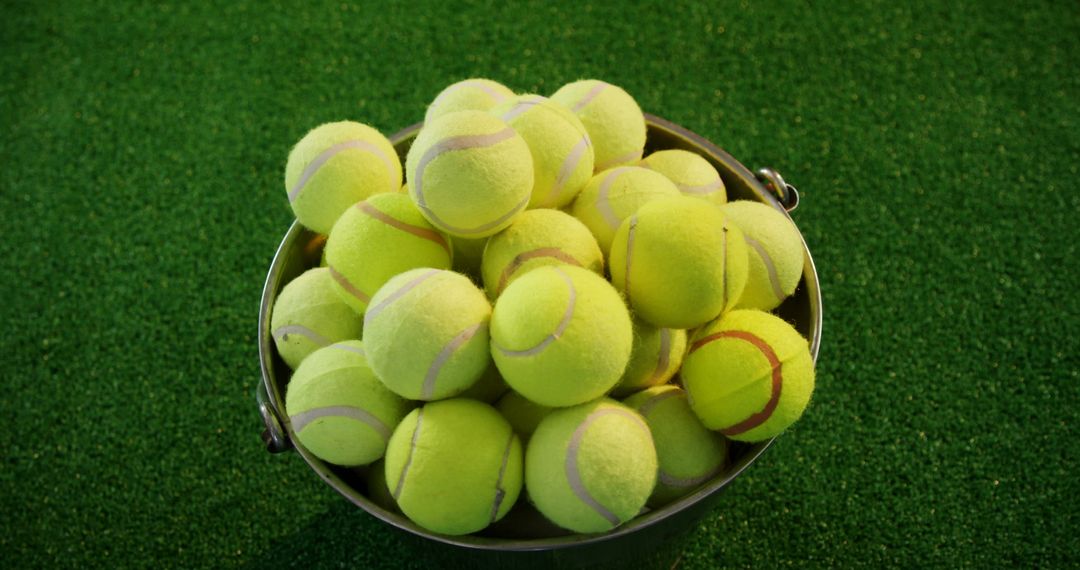 Bucket Filled with Tennis Balls on Green Court - Free Images, Stock Photos and Pictures on Pikwizard.com