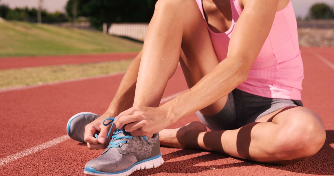 Woman Tying Running Shoes on Outdoor Track - Free Images, Stock Photos and Pictures on Pikwizard.com