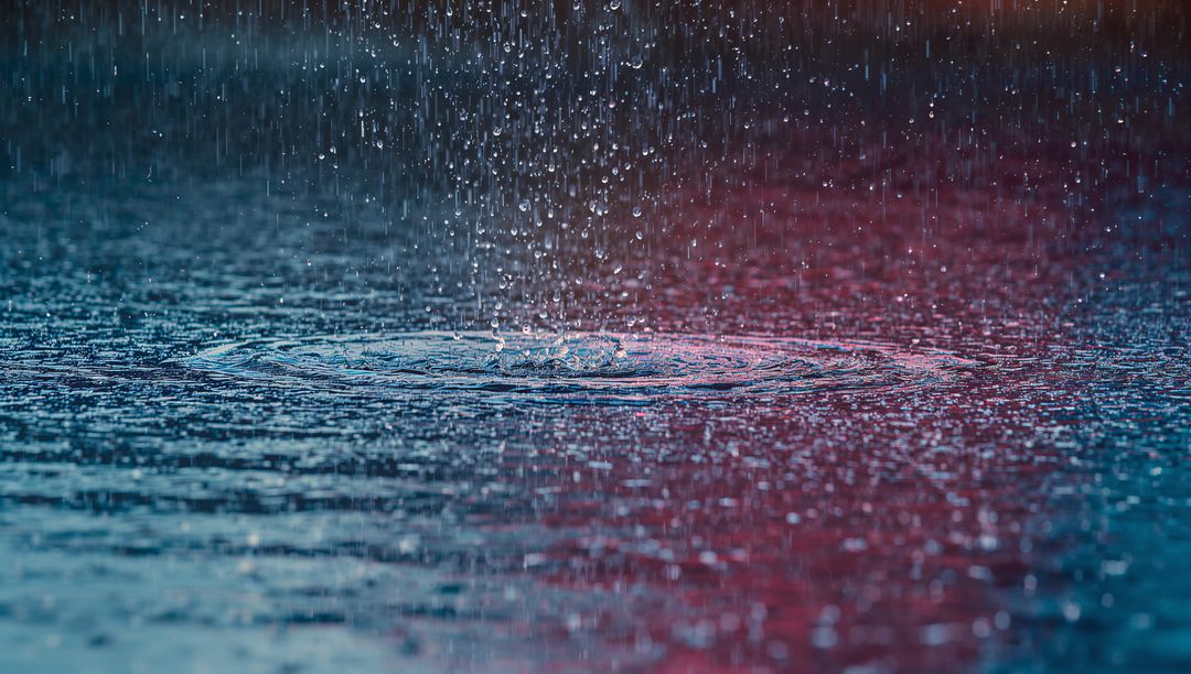 Rain Droplets Creating Concentric Ripples in Vibrant Colors