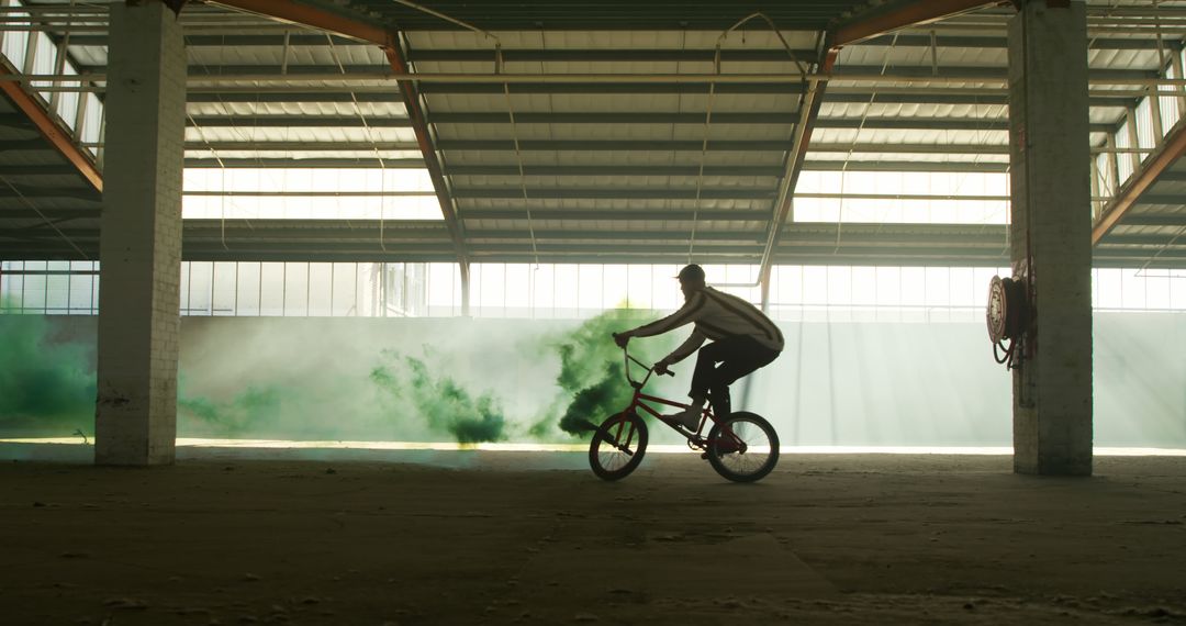 Cyclist Performing Stunt in Abandoned Warehouse with Smoke Effects - Free Images, Stock Photos and Pictures on Pikwizard.com