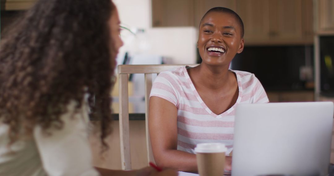 Diverse Friends Smiling While Working on Laptop at Home