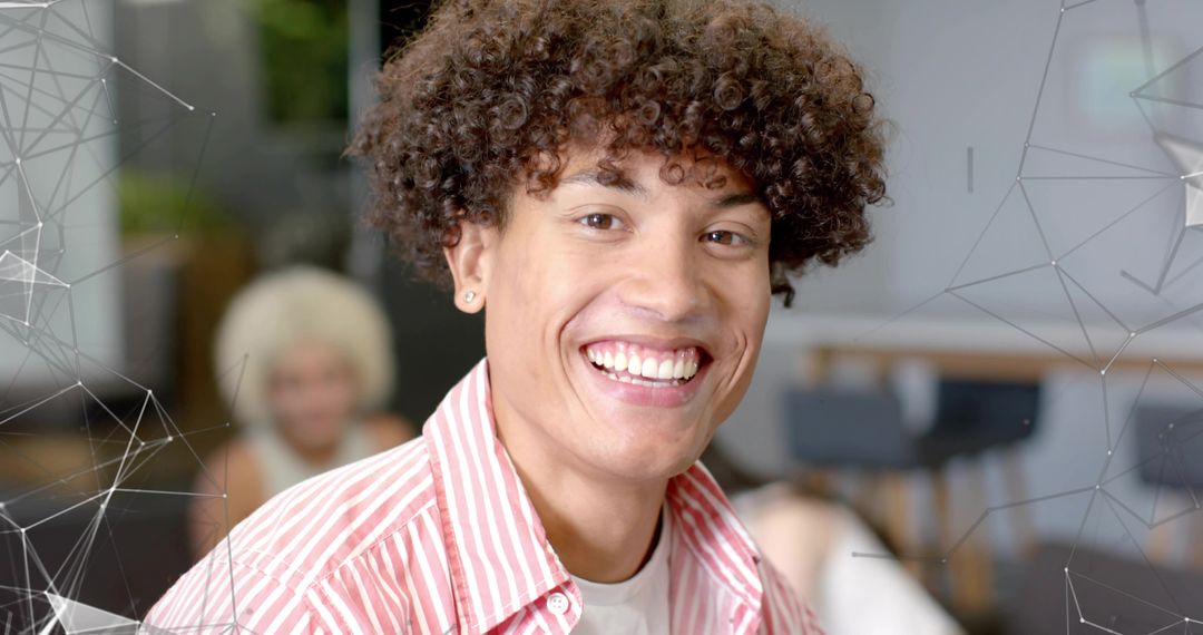Smiling young professional with curly hair and earring in vibrant coworking space