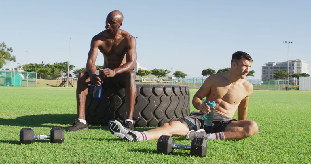Two Fit Men Resting After Outdoor Workout with Tire and Dumbbells - Free Images, Stock Photos and Pictures on Pikwizard.com