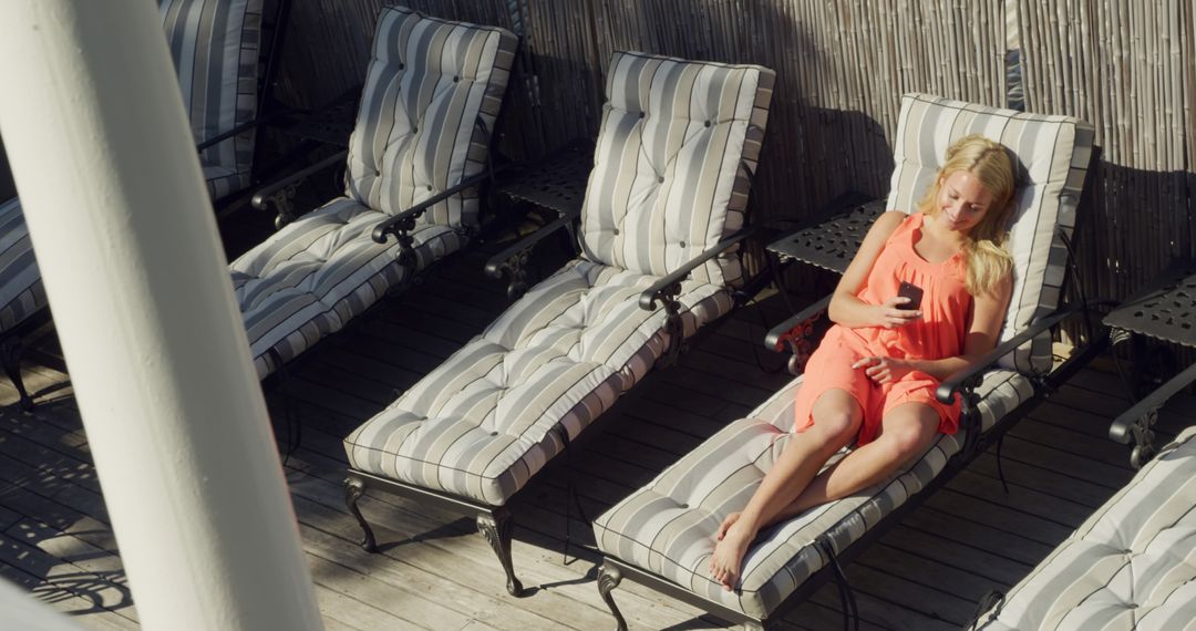 Woman Relaxing on Outdoor Lounge Chair in Sunlight - Free Images, Stock Photos and Pictures on Pikwizard.com