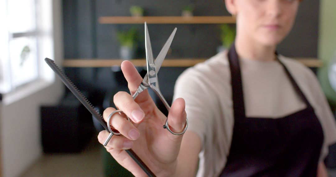 Professional Hairdresser Holding Scissors and Comb in Salon