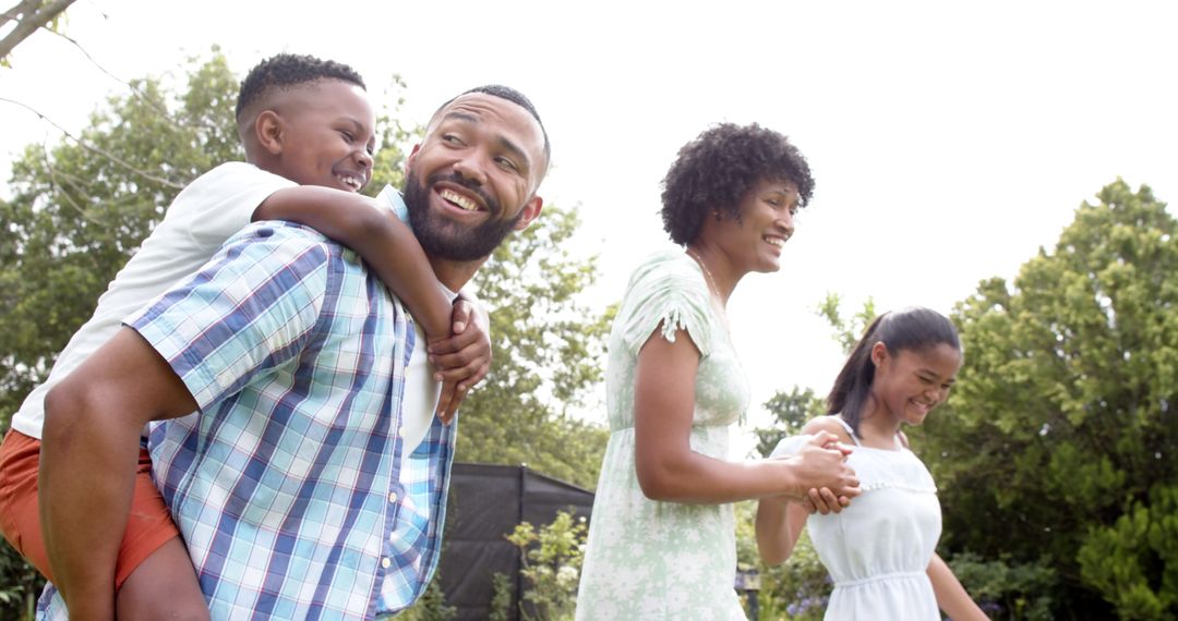 Happy Family Strolling in Sunny Garden Joyously Bonding