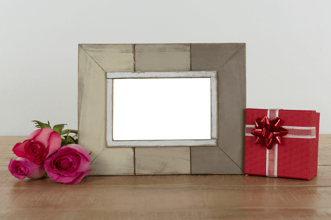 Transparent Photo Frame with Roses and Gift on Wooden Table Setting