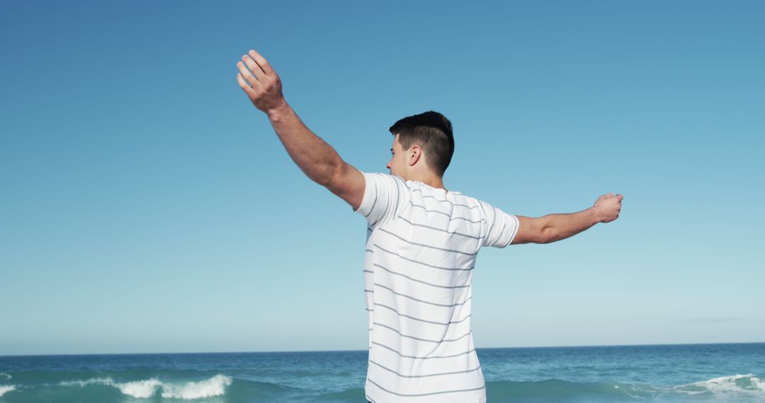 Man Enjoying Freedom at Beach with Hands Outstretched - Free Images, Stock Photos and Pictures on Pikwizard.com