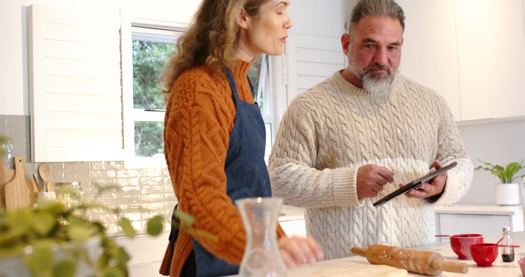 Couple Preparing Dough While Consulting Tablet in Sunlit Modern Kitchen