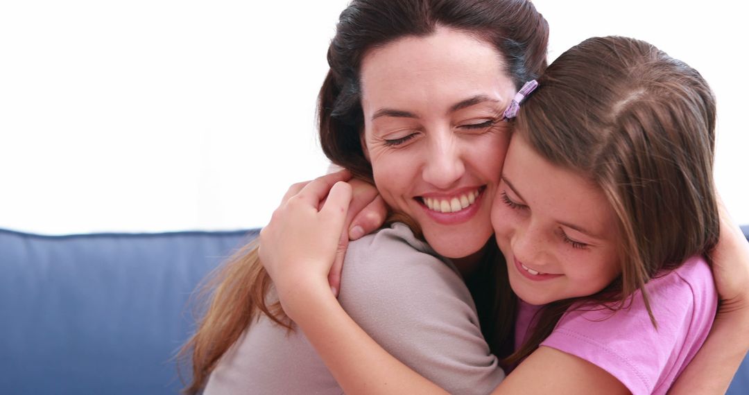 Mother and Daughter Sharing Happy Hug on Couch - Free Images, Stock Photos and Pictures on Pikwizard.com