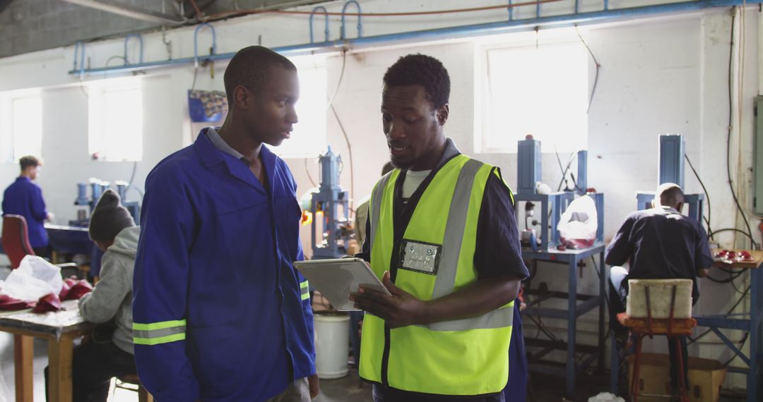 Employees Discussing Work Plans in Manufacturing Workshop - Free Images, Stock Photos and Pictures on Pikwizard.com