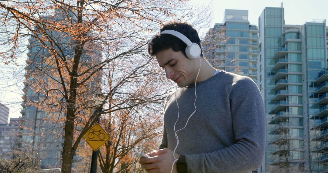 Millennial with Headphones Enjoying Music in Urban Environment - Free Images, Stock Photos and Pictures on Pikwizard.com