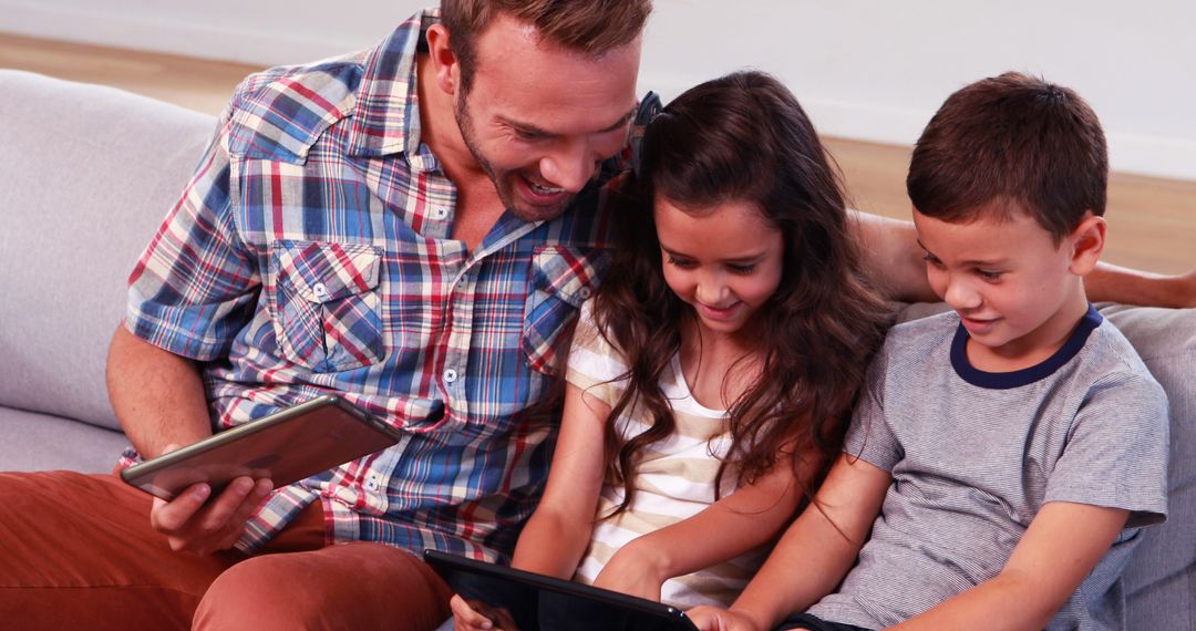 Father Sharing Digital Tablet Experience with Children on Sofa - Free Images, Stock Photos and Pictures on Pikwizard.com