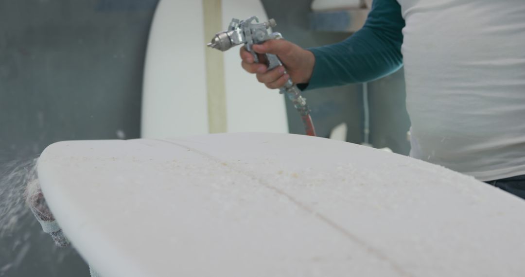 Craftsman Shaping Surfboard in Workshop Using Spray Gun - Free Images, Stock Photos and Pictures on Pikwizard.com