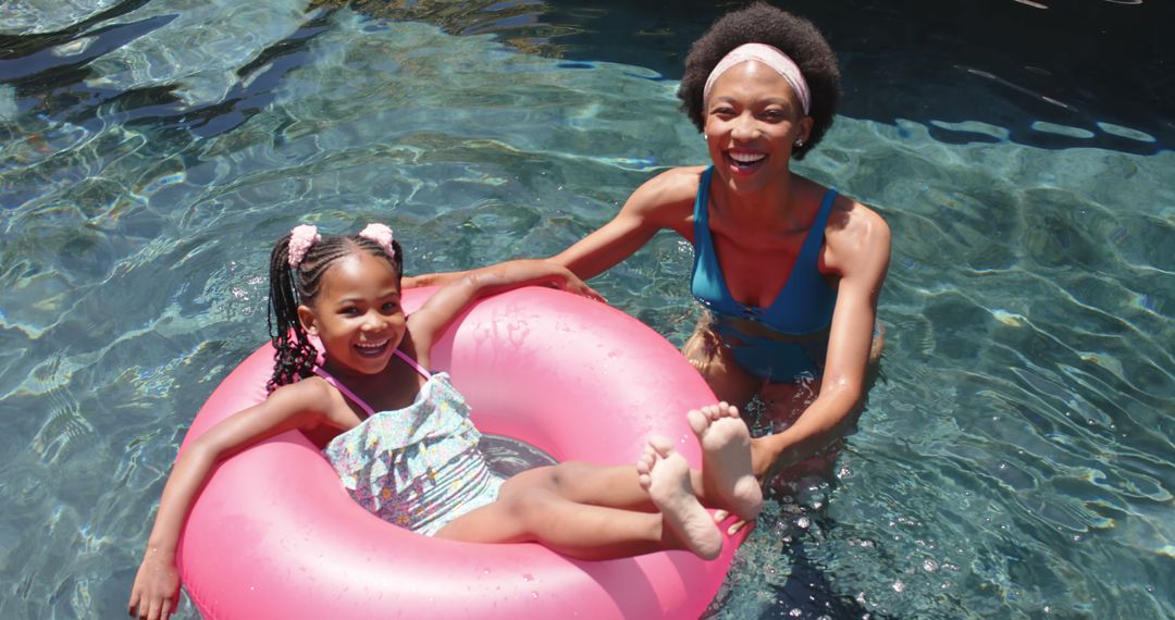 Mother and Daughter Enjoying Pool Time with Inner Tube - Free Images, Stock Photos and Pictures on Pikwizard.com