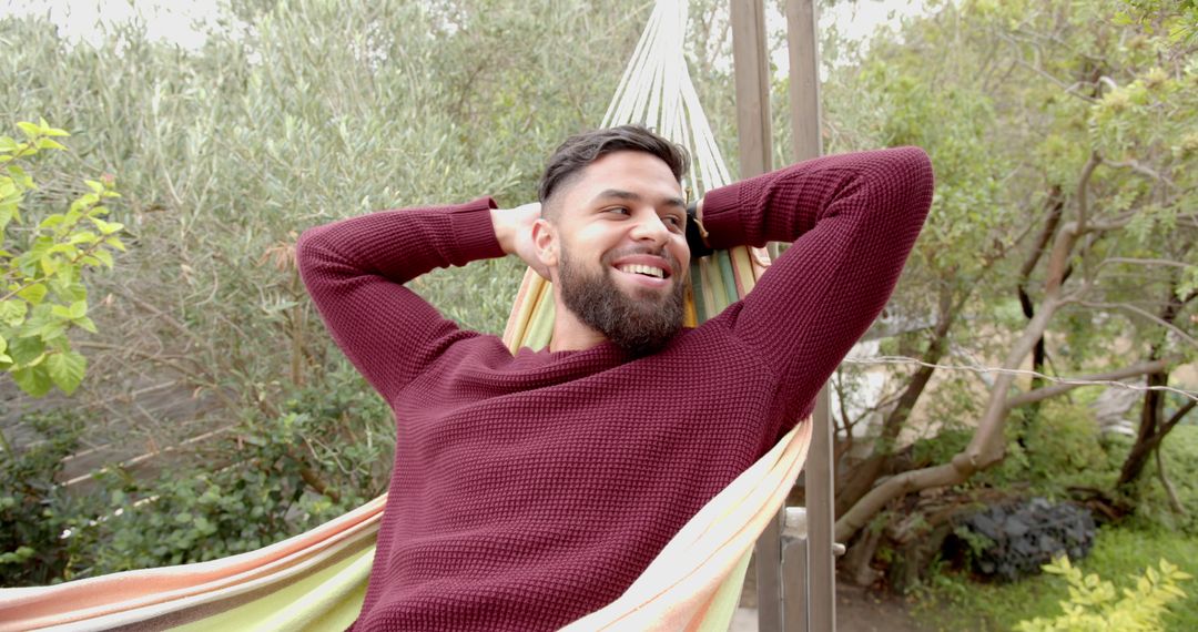 Man Relaxing on Striped Hammock in Lush Garden Setting