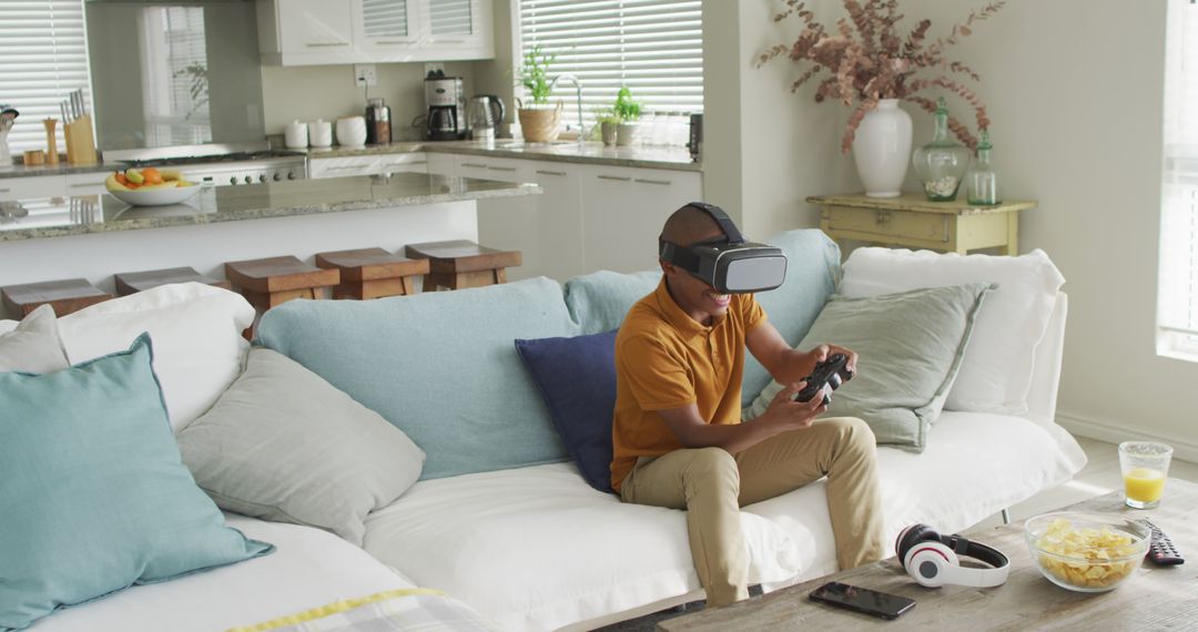 Man Using VR Headset and Controller in Modern Living Room - Free Images, Stock Photos and Pictures on Pikwizard.com