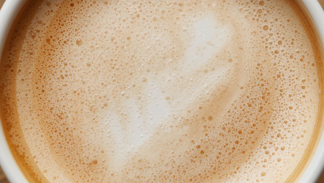 Overhead Latte Foam Texture with Microfoam Bubbles and Creamy Swirl in Ceramic Cup