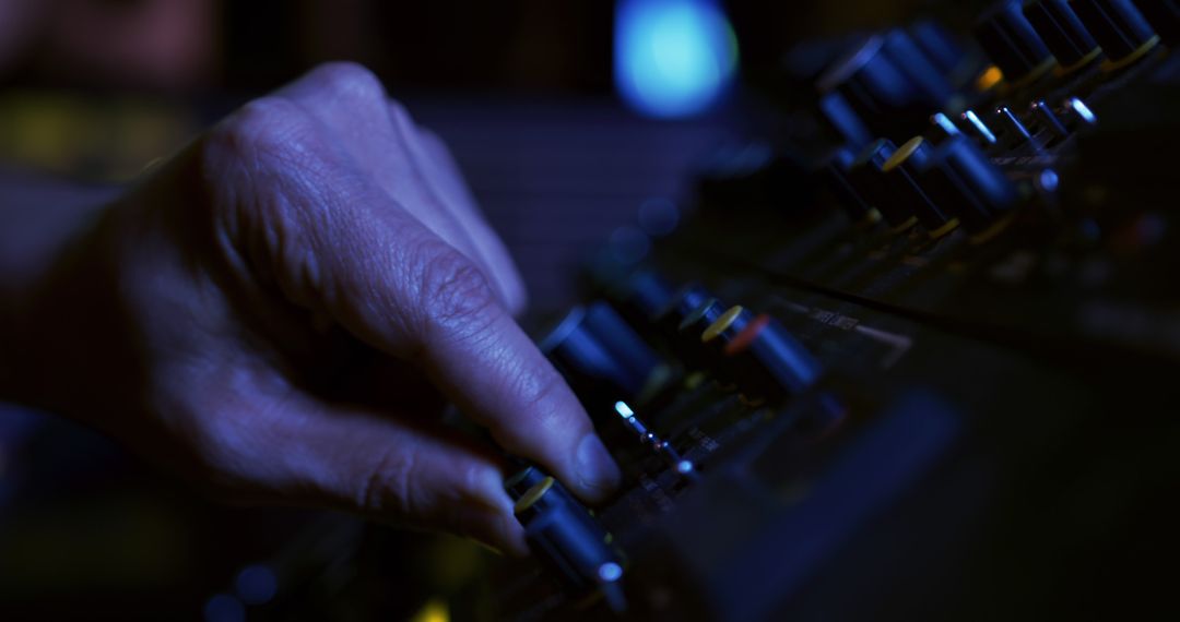 Close-up of Hand Adjusting Audio Mixing Console in Studio Lighting - Free Images, Stock Photos and Pictures on Pikwizard.com