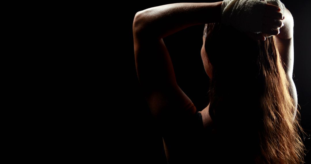 Female Boxer Preparing for Training with Hand Wraps in Dark Studio - Free Images, Stock Photos and Pictures on Pikwizard.com