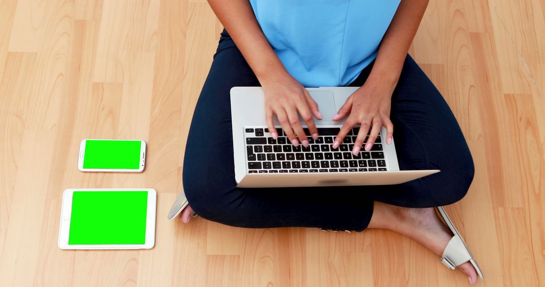 Person Typing on Laptop with Tablets on Wooden Floor - Free Images, Stock Photos and Pictures on Pikwizard.com