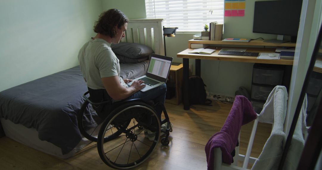 Man in Wheelchair Working on Laptop in Bedroom Office - Free Images, Stock Photos and Pictures on Pikwizard.com