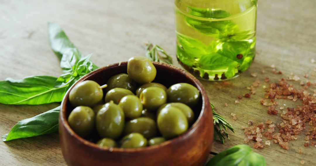 Close-Up of Green Olives in Wooden Bowl with Olive Oil on Table - Free Images, Stock Photos and Pictures on Pikwizard.com